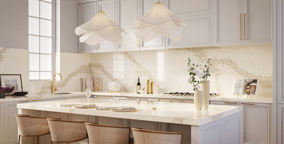 Elegant traditional kitchen with light-gray paneled cabinets, a white and gold-veined Calacatta Nectar quartz island, brass hardware, and wavy pendant lights