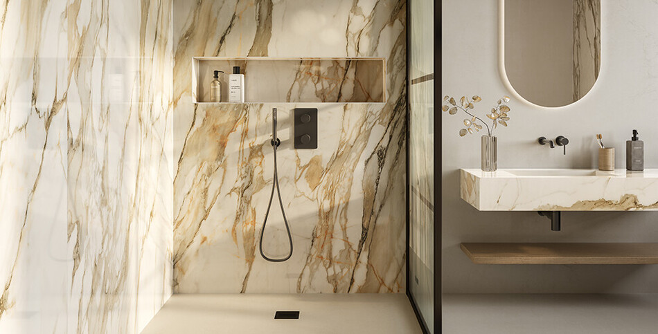 Contemporary bathroom featuring highly veined gold and white Antikella porcelain slabs on the shower walls and floating vanity, showcasing a seamless, waterproof, and hygienic luxury marble look.